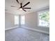 Light gray bedroom with modern ceiling fan, carpet, and lots of natural light at 4731 Whispering Oaks Dr, Charlotte, NC 28213