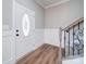 Bright foyer featuring wood flooring, decorative trim, and an elegant staircase with iron accents at 4731 Whispering Oaks Dr, Charlotte, NC 28213
