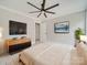 This main bedroom offers a ceiling fan, large screen tv, and artwork for a relaxing retreat at 4731 Whispering Oaks Dr, Charlotte, NC 28213
