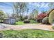 Large backyard with a storage shed, mature trees, and a manicured lawn at 501 Eastwood Dr, Gastonia, NC 28054