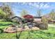 Backyard with a built-in fire pit, grill, mature trees, and manicured lawn at 501 Eastwood Dr, Gastonia, NC 28054