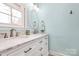 Elegant bathroom featuring double sinks, a marble countertop, and a large window at 501 Eastwood Dr, Gastonia, NC 28054