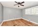 Bedroom showcasing hardwood floors, neutral wall paint, a ceiling fan, and natural light from the window at 501 Eastwood Dr, Gastonia, NC 28054