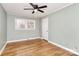 Bright bedroom featuring hardwood floors, a ceiling fan, and a large window at 501 Eastwood Dr, Gastonia, NC 28054