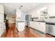 Open kitchen layout with stainless steel refrigerator, granite countertops, white cabinetry, and hardwood floors at 501 Eastwood Dr, Gastonia, NC 28054