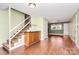 Cozy living room with wooden floors, staircase, and built-in wooden cabinet for storage and display at 501 Eastwood Dr, Gastonia, NC 28054