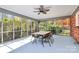Bright enclosed patio featuring a dining set, ceiling fan, and screened windows with a view of the lush backyard at 501 Eastwood Dr, Gastonia, NC 28054