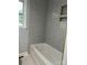 Neutral toned bathroom with sleek tub and shower with built in shelf at 609 Mccarten St, Monroe, NC 28112