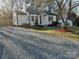 Landscaped yard with manicured beds, a gravel driveway, and a charming home with a classic design at 609 Mccarten St, Monroe, NC 28112