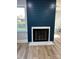 Modern fireplace with white marble surround and black interior, set against a dark blue accent wall at 609 Mccarten St, Monroe, NC 28112