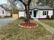 Charming single-story home with white siding, black shutters, and a beautifully landscaped front yard with a large tree at 609 Mccarten St, Monroe, NC 28112