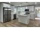Modern kitchen with stainless steel appliances, white cabinets, an island, and new lighting at 609 Mccarten St, Monroe, NC 28112