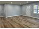 Open living room featuring a large window, hardwood floors, and neutral wall colors at 609 Mccarten St, Monroe, NC 28112
