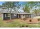 Charming home with a dark gray exterior and a quaint screened-in porch and yard at 6501 Thamesmead Ln, Mint Hill, NC 28227