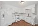 Well-lit kitchen featuring white appliances and cabinetry against a hardwood floor at 6501 Thamesmead Ln, Mint Hill, NC 28227