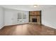 Bright living room featuring a stone fireplace, large windows, and hardwood floors throughout at 6501 Thamesmead Ln, Mint Hill, NC 28227