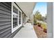 Covered front porch with a concrete floor, classic columns, and tasteful landscaping at 6501 Thamesmead Ln, Mint Hill, NC 28227