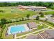 An aerial view of a community pool near a school with a playground surrounded by lush greenery at 7426 Calhoun Falls Dr, Rock Hill, SC 29732