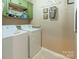 A laundry room featuring a washing machine and a dryer with decorative wall hangings and a shelf above at 7426 Calhoun Falls Dr, Rock Hill, SC 29732