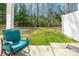 Outdoor patio featuring a cushioned chair and table, surrounded by lush greenery and a wooded area at 7426 Calhoun Falls Dr, Rock Hill, SC 29732