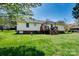 Wide view of the backyard featuring a deck, birdbath, and well-maintained lawn at 841 E Zion Church Rd, Shelby, NC 28150