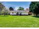 Back exterior view of the home with large backyard, mature trees, and wooden deck at 841 E Zion Church Rd, Shelby, NC 28150