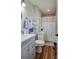 Well-lit bathroom showcasing gray vanity, round mirror, and a shower with neutral curtain at 841 E Zion Church Rd, Shelby, NC 28150