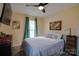Comfortable bedroom with light yellow walls, ceiling fan, and accent artwork and decor at 841 E Zion Church Rd, Shelby, NC 28150