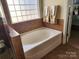 Bathroom features neutral tile, a bright window, and a large soaking tub at 86614 Arrington Rd, Lancaster, SC 29720