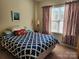 Bedroom featuring a patterned comforter, side table, and window with curtains at 86614 Arrington Rd, Lancaster, SC 29720