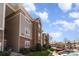 Exterior shot of multi-story apartment buildings and parking lot on a clear day at 9810 Campus Walk Ln # G, Charlotte, NC 28262