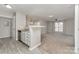 Sunlit open-concept living room, seamlessly blending kitchen space with cozy carpet and recessed lights at 9810 Campus Walk Ln # G, Charlotte, NC 28262