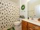 Well-lit bathroom with a shower featuring a whimsical tree-patterned curtain, and wooden vanity at 1021 Glen Laurel Dr, Fort Mill, SC 29707