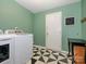 Clean laundry room with modern washer and dryer, black and white patterned flooring, and green walls at 1021 Glen Laurel Dr, Fort Mill, SC 29707