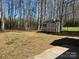 Spacious backyard featuring mature trees and an outdoor storage shed at 10607 Wood Meadow Dr, Charlotte, NC 28227
