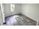 Bright bedroom featuring sleek, grey wood-look flooring and fresh, neutral paint at 10607 Wood Meadow Dr, Charlotte, NC 28227