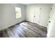 Bright bedroom featuring sleek, grey wood-look flooring and fresh, neutral paint at 10607 Wood Meadow Dr, Charlotte, NC 28227