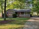 Charming brick home featuring a well-maintained lawn and red shutters at 10607 Wood Meadow Dr, Charlotte, NC 28227