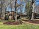 Charming brick home featuring a red front door, a cozy porch, and a well-maintained front yard with mature trees at 10607 Wood Meadow Dr, Charlotte, NC 28227