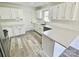 Modern kitchen featuring white cabinets, countertops, and subway tile backsplash, with updated appliances and flooring at 10607 Wood Meadow Dr, Charlotte, NC 28227