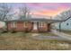 Charming brick home featuring a covered parking area, landscaped front yard, and inviting front porch with sunrise background at 108 White Oak St, Chester, SC 29706