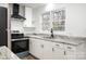 Kitchen with stainless steel appliances, granite counters, white cabinets, and vinyl flooring at 108 White Oak St, Chester, SC 29706