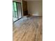 Open living area featuring wood-look tile flooring and brick fireplace with sliding glass doors to the deck at 11022 Harrowfield Rd, Charlotte, NC 28226
