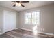 Bedroom features hardwood flooring, a ceiling fan, closet, and a view through a window at 121 Wichita Dr, Shelby, NC 28152