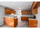 A spacious kitchen features warm wood cabinetry, stainless appliances, and a bar counter for seating at 121 Wichita Dr, Shelby, NC 28152