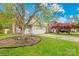 Beautiful front yard showcasing a well-maintained lawn, flowering trees, and the home's charming facade at 13521 Michael Lynn Rd, Charlotte, NC 28278