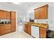 Kitchen view showcasing wood cabinets, granite countertops, stainless steel sink and white dishwasher at 13521 Michael Lynn Rd, Charlotte, NC 28278