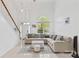 Inviting living room featuring a soaring ceiling, staircase, and a modern sectional sofa with decorative pillows at 13521 Michael Lynn Rd, Charlotte, NC 28278