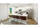 Bright kitchen boasts white cabinets, stainless steel appliances, quartz counters, and a large island with seating at 140 Falling Up Ln, Salisbury, NC 28147