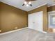 This bedroom features neutral walls, plush carpet, a closet, and access to the next room at 153 Stafford Estates Dr, Salisbury, NC 28146